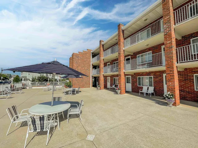 a patio with a table and chairs under an umbrella