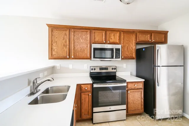 a kitchen with stainless steel appliances granite countertop a refrigerator stove and sink