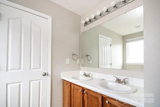 a bathroom with a sink double vanity and a mirror
