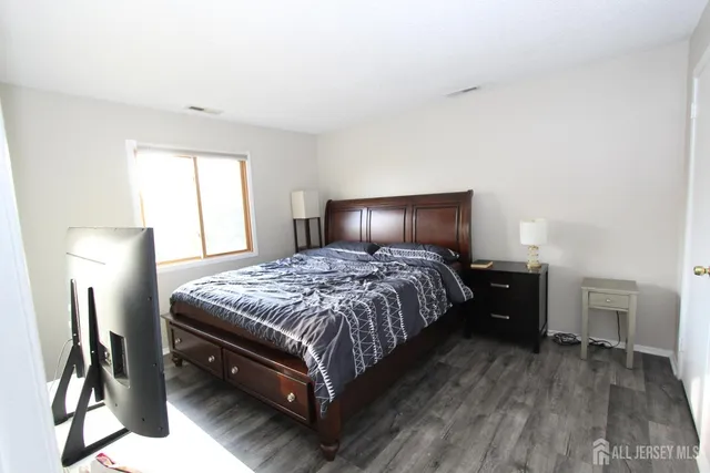 a bedroom with a bed lamps and a dresser