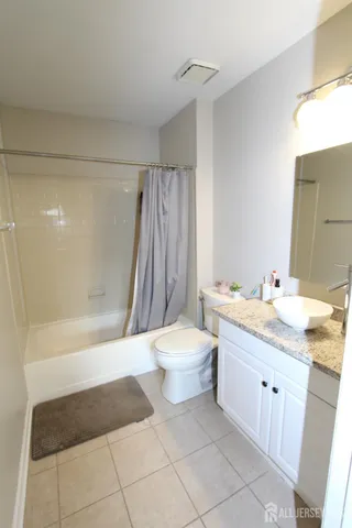 a bathroom with a granite countertop sink toilet a mirror and shower