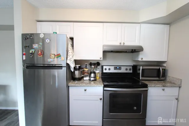 a kitchen with stainless steel appliances granite countertop a stove and a refrigerator