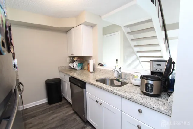 a kitchen with sink a stove and cabinets