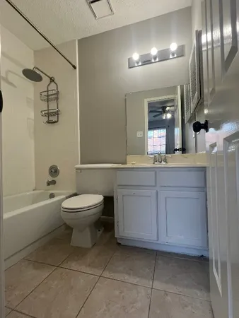 a bathroom with a toilet a sink a mirror and bathtub