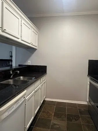 a kitchen with granite countertop a sink and a stove