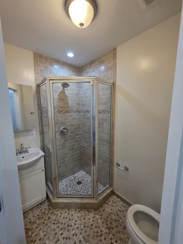 a bathroom with a shower a toilet and sink