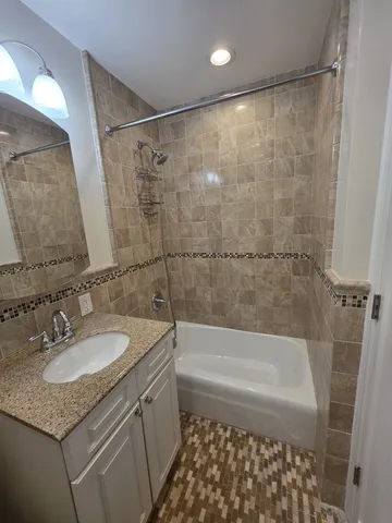 a bathroom with a granite countertop sink a toilet and shower
