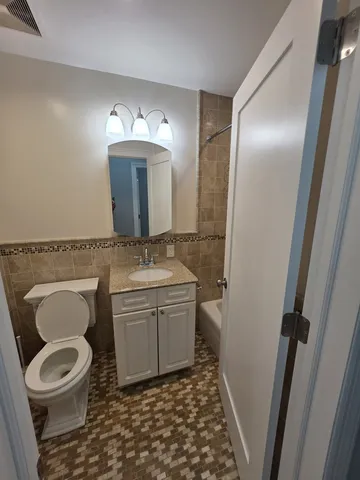 a bathroom with a granite countertop toilet and a sink
