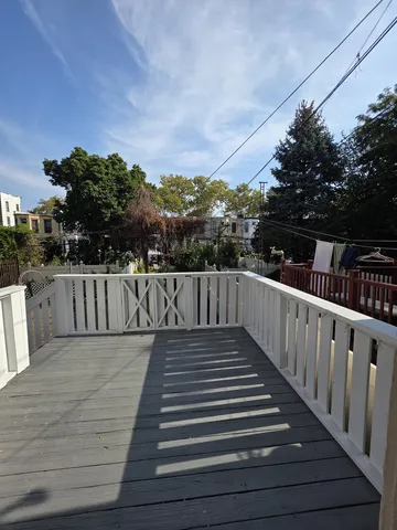 a view of deck with wooden floor and fence with trees