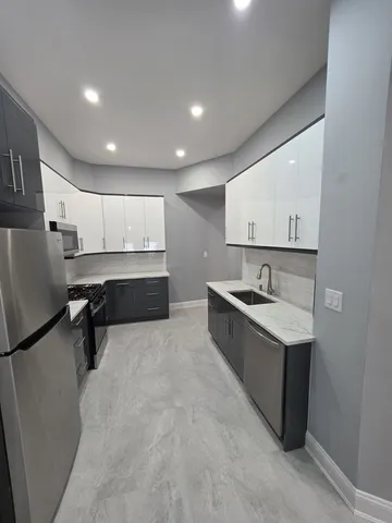 a large kitchen with a sink and refrigerator
