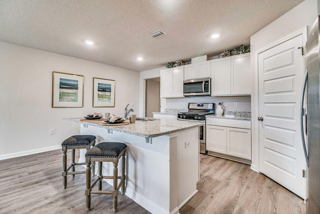 2837 Patriot Ridge Way Crestview, FL 32539 - Photo 4 of 35 a kitchen with a sink cabinets and wooden floor