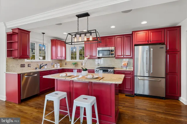 a kitchen with stainless steel appliances granite countertop a sink stove a refrigerator and island