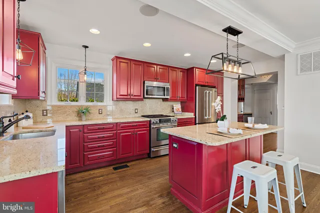 a kitchen with stainless steel appliances kitchen island granite countertop a sink stove and refrigerator