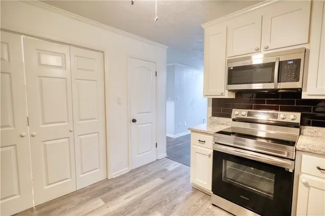 a kitchen with stainless steel appliances wooden cabinets and a stove top oven