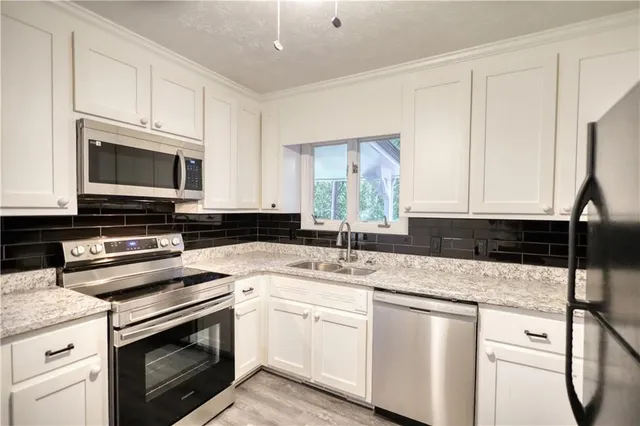 a kitchen with a sink stove and microwave