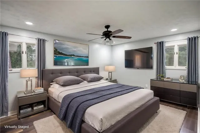 a bedroom with a large bed a flat screen tv and a window