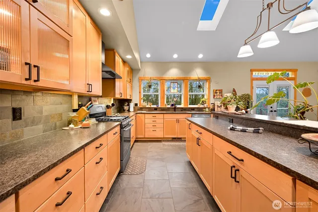 a large kitchen with stainless steel appliances kitchen island granite countertop a sink and cabinets