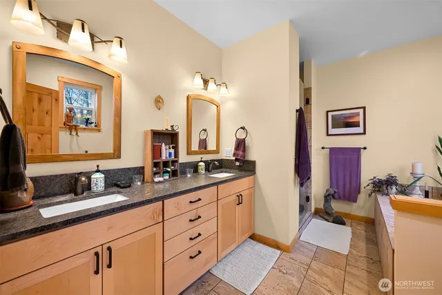 a bathroom with double vanity sinks a vanity and a mirror