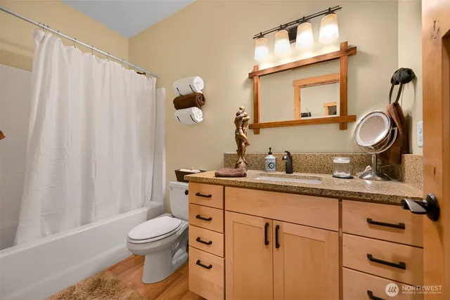 a bathroom with a granite countertop toilet sink and mirror