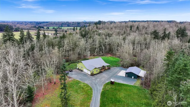 an aerial view of a house with a yard and lake view