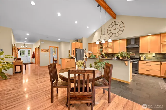 a dining room with stainless steel appliances kitchen island granite countertop a table chairs and a dining table view
