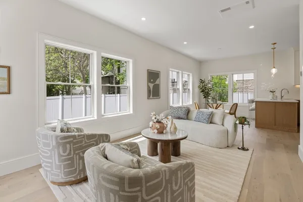 a living room with furniture and floor to ceiling windows