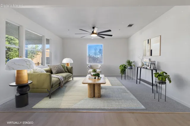 an empty room with windows and chandelier fan