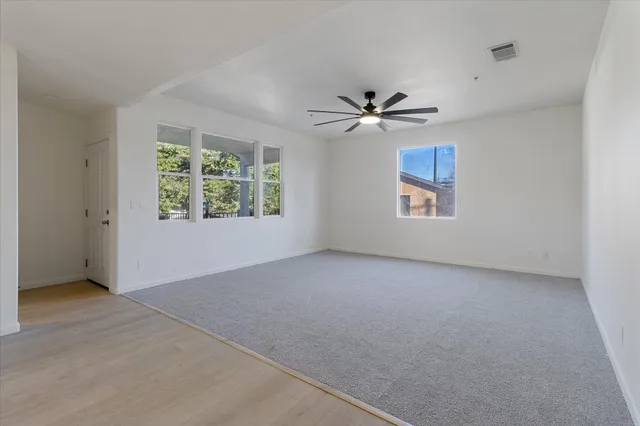 a view of an empty room with a ceiling fan