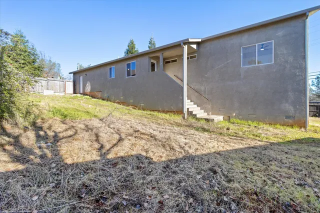 a view of a house with backyard and sitting area
