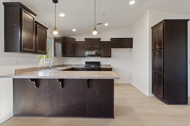 a kitchen with stainless steel appliances granite countertop a sink and a stove