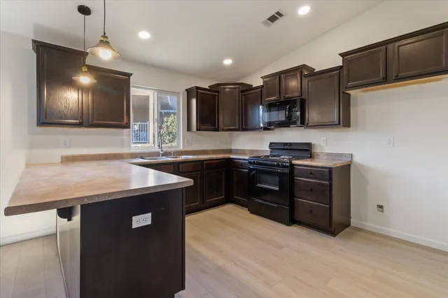 a kitchen with granite countertop stainless steel appliances and wooden cabinets