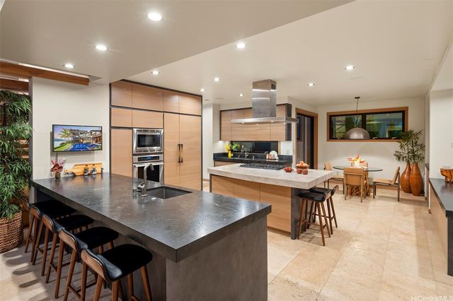 a kitchen with stainless steel appliances kitchen island granite countertop a table and chairs in it