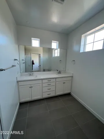 a bathroom with a double vanity sink a mirror and a bathtub