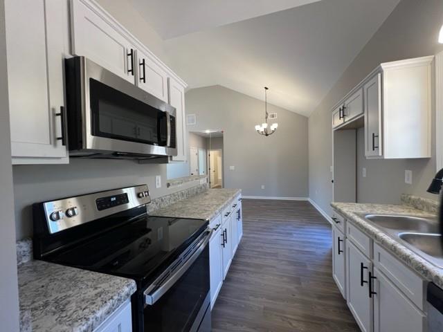 a kitchen with stainless steel appliances granite countertop a stove a sink and a microwave