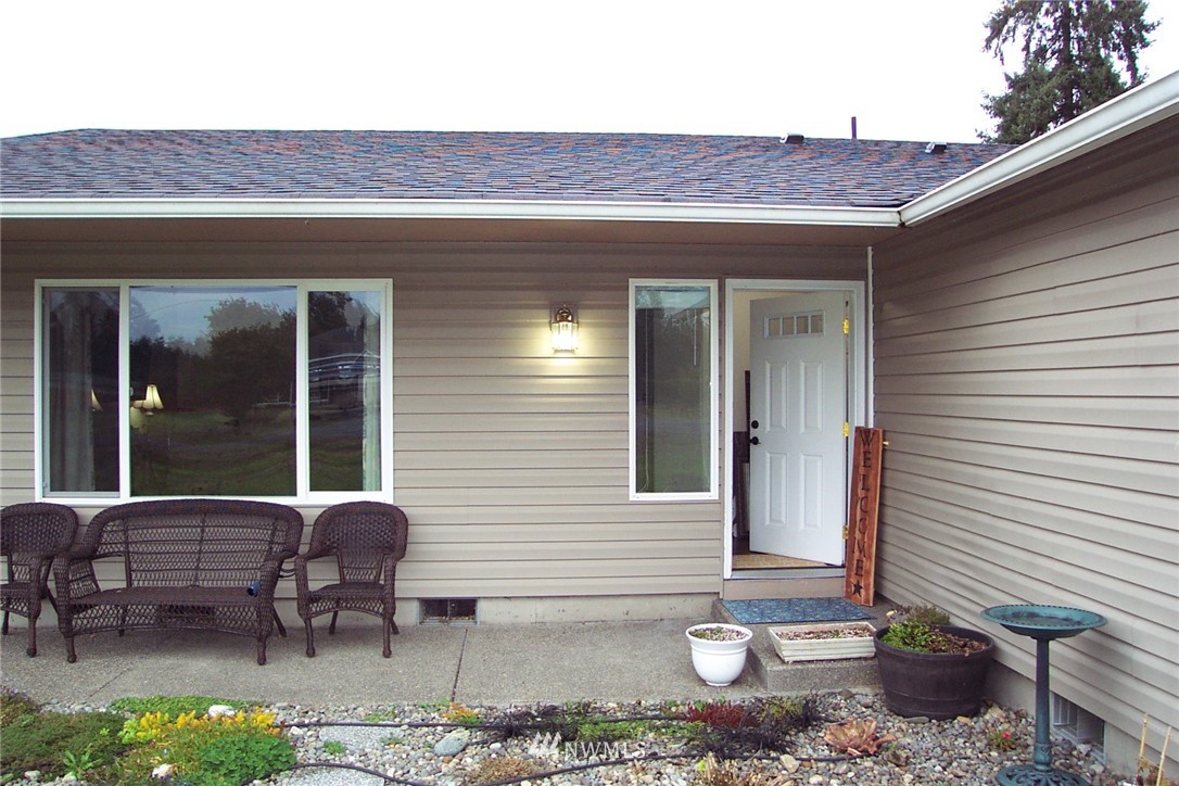 9222 176th Avenue Southwest Rochester, WA 98579 - Photo 2 of 21 a view of a patio with table and chairs and floor to ceiling window