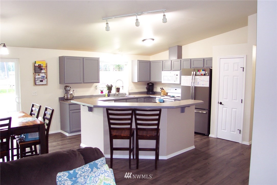 9222 176th Avenue Southwest Rochester, WA 98579 - Photo 6 of 21 a kitchen with a table chairs refrigerator and microwave