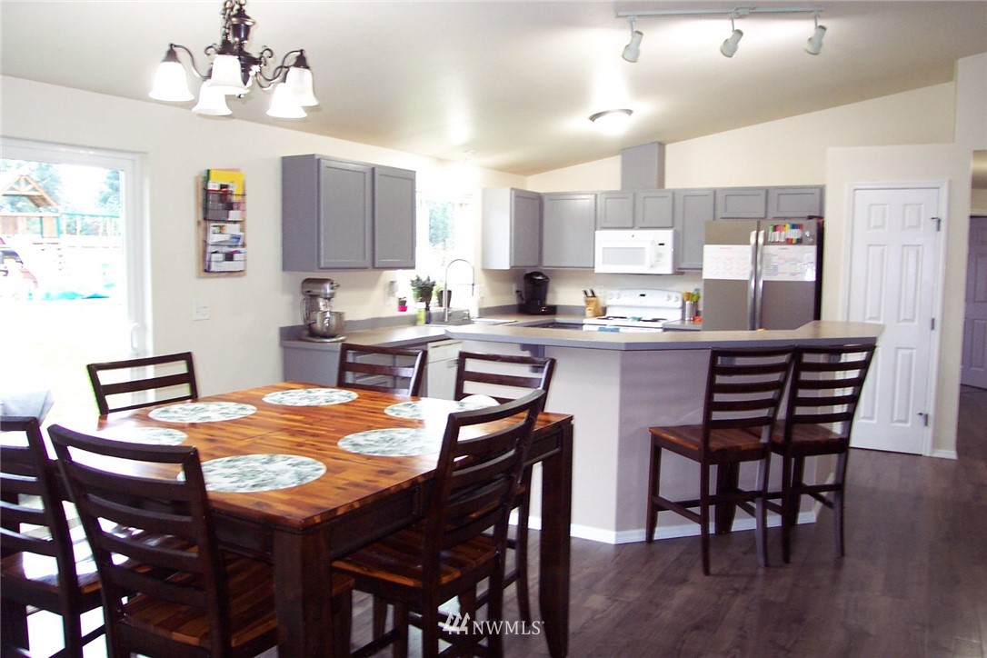9222 176th Avenue Southwest Rochester, WA 98579 - Photo 7 of 21 a kitchen with stainless steel appliances granite countertop a sink a stove a dining table and chairs
