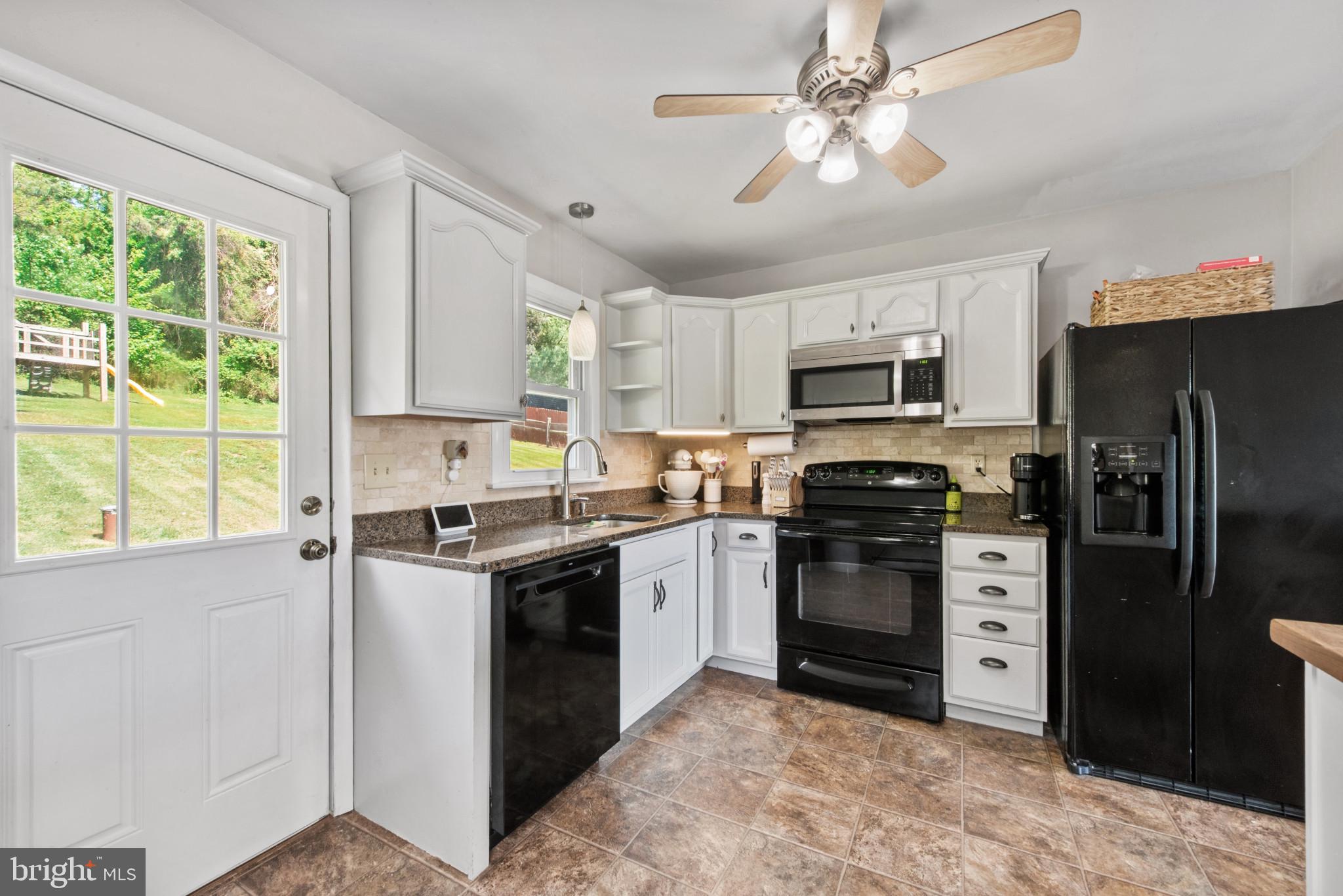 3242 Lineboro Road Manchester, MD 21102 - Photo 10 of 30 a kitchen with stainless steel appliances granite countertop a stove refrigerator sink and microwave