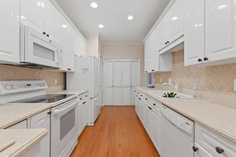a large kitchen with stainless steel appliances lots of counter space sink and wooden floor
