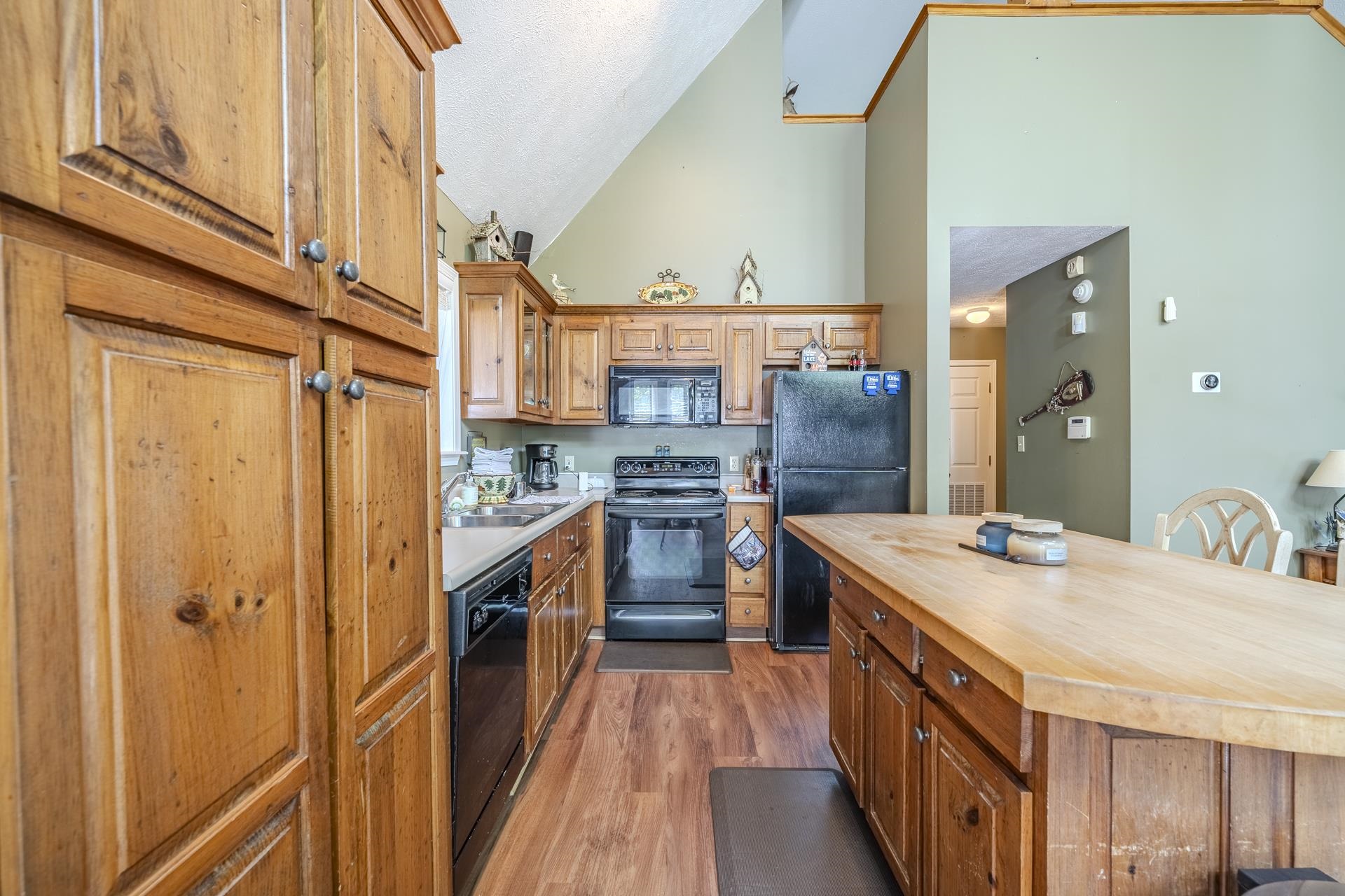 435 Murray Lane Counce, TN 38326 - Photo 13 of 34 Kitchen featuring wood-finish flooring, ample wood cabinetry, black appliances, a counter-depth sink, and a substantial center island with wood countertop