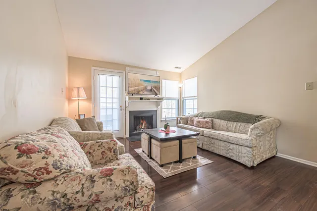 a living room with furniture a fireplace and a large window