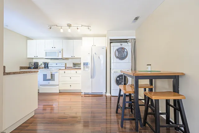 a kitchen with stainless steel appliances granite countertop a stove top oven a dining table and chairs with wooden floor