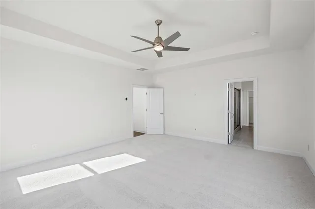 an empty room with closet and a ceiling fan