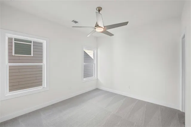 an empty room with a window and ceiling fan