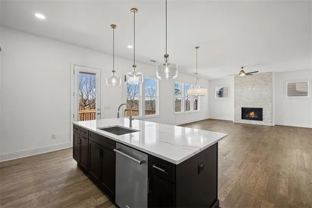 a kitchen with stainless steel appliances granite countertop a sink a refrigerator a stove and a wooden floors