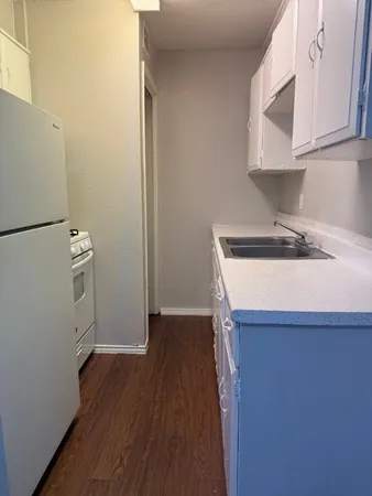 a kitchen with a sink a microwave and cabinets