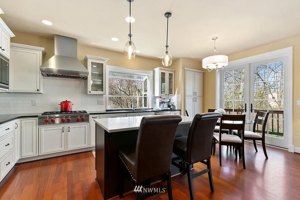 16204 40th Avenue Southeast Bothell, WA 98012 - Photo 6 of 24 a kitchen with stainless steel appliances granite countertop wooden floor dining table and chairs