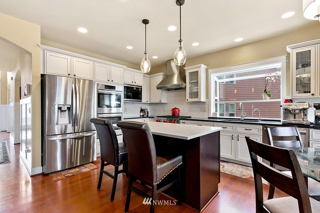 16204 40th Avenue Southeast Bothell, WA 98012 - Photo 7 of 24 a kitchen with stainless steel appliances granite countertop a sink a stove a refrigerator and chairs