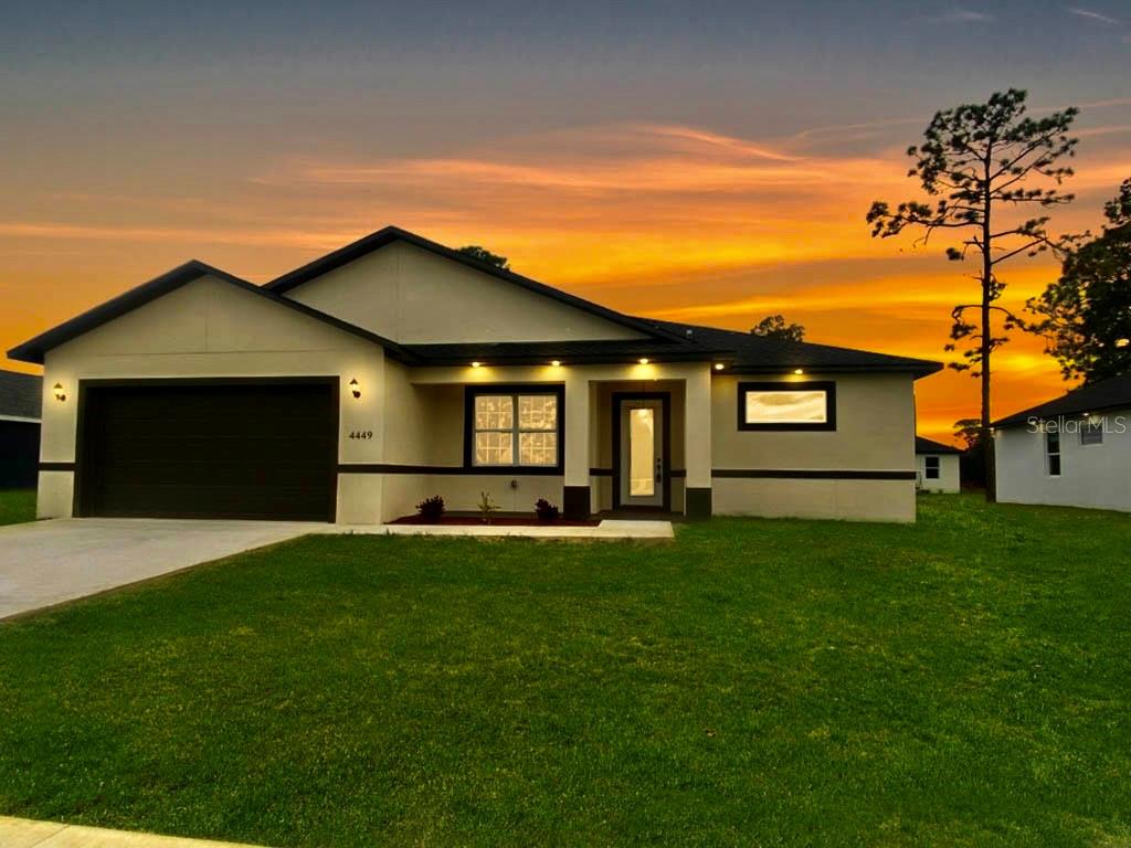 a front view of a house with a garden and yard