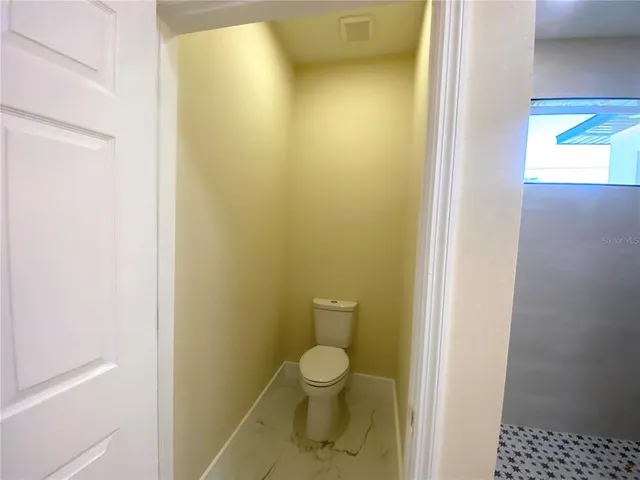 a bathroom with a granite countertop toilet and a sink